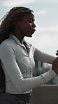 Fitness, woman or running outdoor with watch for cardio endurance, workout distance or track pace. Jog, black person and runner check time in city for exercise performance, pulse or health stats