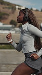 Exercise, woman and running in city with music for cardio endurance, workout or streaming radio. Headphones, black person and runner outdoor for health lifestyle, training playlist or fitness audio