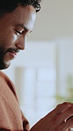 Texting, online and man with phone in home, happy or communication with contact on social media app. Typing, message and person with mobile, internet connection and chatting with smile in house