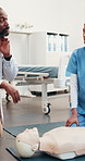 Doctor, dummy and nurse at hospital for cpr, demonstration and medical practical for critical care. Specialist, teaching and person in clinic with mannequin, training nursing intern and resuscitation