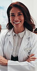 Meeting, face and doctor in hospital with arms crossed, clinical service or pride in medical career. Happy, team or mature woman with confidence, general practitioner or about us in health industry.