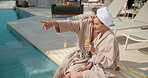 Hotel, talking and couple by pool with drink for vacation, holiday and bonding on weekend getaway. Marriage, relax and man with woman with juice, alcohol and conversation for love, break and travel