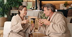 Tea, couple and talking at spa for relax, laughing or comfort on anniversary holiday for love. Herbal drinks, mature man and woman with funny joke at luxury resort, vacation and smile with partner