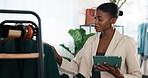 Woman, tablet and inspection in fashion store with clothing rack, stock and quality control report. Boutique, owner and black person typing with tech for inventory management, retail plan and smile.