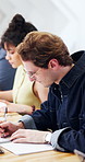 College student, writing and man with notebook, education and planning for assignment in classroom. University, notes and person with tablet, thinking and exam preparation with information on website