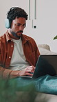Home, music and man with laptop for remote work, song writer or typing for lyrics composition. Computer, headphones and freelancer on sofa with audio chorus, production research and rhyme scheme
