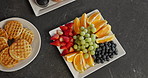 Fruit, platter or breakfast in kitchen with waffles on counter for morning diet or organic food. Top view, variety or natural meal with vitamin C for nutrition, fiber or sweet snack on table in house