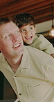 Fun, father and boy in house with piggyback, bonding together and happy moment in living room. Smile, dad and child with family game, parent connection and quality time in playful relationship.
