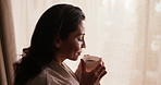 Happy, window and woman with drink at hotel for break on vacation, holiday and relax in morning. Travel, calm and person with coffee, reflection and view for accommodation, hospitality and getaway