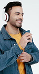 Karaoke, headphones and man with phone, dancing fun and groove performance with music streaming. Happy, rhythm and person with tech, feeling beat and radio entertainment on studio background.