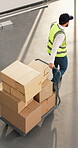 Man, trolley and boxes in warehouse for logistics, material handling and b2b distribution of goods. Above, back and transfer driver with cart for inbound receiving, restock order or transport freight