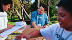 Volunteer, sorting or team in park with donation, clothing pack or inventory prep in charity program. Happy, man or NGO with garment box, distribution management or group support in outreach project.