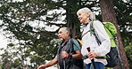 Hiking, fitness and old couple talk in nature with trip, vitality or explore together for retirement. Low angle, senior people and point outdoor with trekking gear, interracial relationship or travel