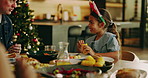 Christmas, family and child eating in home for lunch, holiday meal or social gathering together. Happy, kid or girl with food for December weekend or festive celebration on dinner table in house
