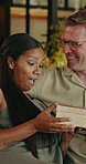 Christmas, shock and couple in home with gift giving, romantic moment and gratitude in xmas season. Love, happy man and woman with cheek kiss, present surprise and thank you in festive celebration.