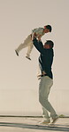 Carrying, child and dad with smile, outdoor and spinning with son on weekend and bonding together. Happy man, fun and playing with kid on break, laughing or connection with father on rooftop at home