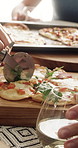 People, hands and dining with pizza for fast food, social gathering or meal serving in home. Pastry chef, cutter and slice with glass, dairy snack or cuisine for ready baked dinner together in house