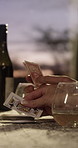 Hands, friends and play cards in home with wine, contest and challenge with entertainment. People, game and competition at apartment with alcohol, gambling and strategy on weekend break together