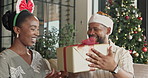 Christmas, present and black couple hug on home sofa for bonding, quality time and gratitude. Happy man, woman or festive season in house with kiss, xmas gift and surprise for holiday celebration
