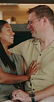 Happy, couple and relax in home with love, connection and romantic partner on valentines day. Smile, interracial people and cuddle in lounge for romance, embrace spouse and affection for commitment