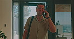 Man, entrance and phone call with communication for arrival, welcome or network connection in home. Male person, homeowner or talking with smile for location, destination or conversation in house