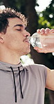 Man, fitness and drink with water in nature for workout break, recovery or sustainability. Active, male person or mineral liquid with aqua bottle for outdoor exercise, rest or hydration in park