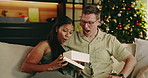 Christmas, surprise and happy couple with gift in home for festive celebration or December holiday. Man, woman or love with kiss, present or box for Santa love, weekend or gratitude together in house