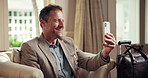 Businessman, talk and video call in hotel with phone, connectivity or update for overseas work trip. Happy, mature person and chat in motel with tech, online meeting or contact for international job.