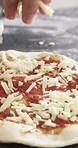 Cooking, pizza and hands of person with cheese in restaurant for catering with dough for meal. Ingredients, tomato sauce and culinary chef with food production for Italian cuisine in kitchen at diner