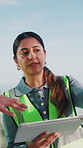 Engineer, talking and woman with tablet on construction site, teamwork and planning for renovation. Civil engineering, outdoor and people with tech, pointing or collaboration for property development