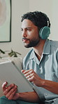 Headphones, thinking and man with tablet on sofa for streaming song, audio and listen to podcast. Home, relax and person on digital tech for radio, track and scroll with music subscription on weekend