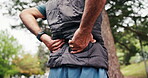 Hiking, hands or old man in nature with back pain, joint injury or burnout in fitness activity. Discomfort, bokeh or elderly person with massage, wellness risk or spine strain in retirement trekking.