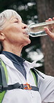 Senior, woman and relax with water for hiking hydration, scenic break or nature appreciation. Thirst, pensioner or smile in forest with refreshing liquid, trekking pause or sightseeing with fresh air