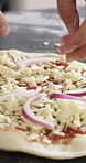 Cooking, pizza and hands of chef with red onion in restaurant for catering with dough for meal. Ingredients, vegetables and culinary worker with food production for Italian cuisine in kitchen.
