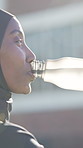 Break, water and Muslim woman outdoor with fitness, training pause or recovery in wellness activity. Hydration, cool down or Arab person with bottle, workout rest or refreshing stop in city exercise.