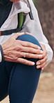 Senior woman, injury and hiking with knee pain, discomfort and trail accident of travel adventure. Hands, elderly person and massage in nature with leg sprain, inflammation and burnout from trekking