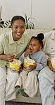 Parents, child and popcorn in home with television, streaming and latest cartoon for bonding. Happy, African family and toddler in lounge with snack, comedy movies and animation video for childcare