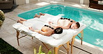 Couple, rest and back at spa with stones, muscle stiffness and heat treatment of deep tissue. Above, people and warm rocks at resort for physical therapy, improve circulation and therapeutic massage