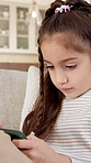 Home, phone and child scroll for game download, online app and weekend entertainment in living room. Mobile, girl and gaming on sofa, playing on internet or connection for browsing website to relax