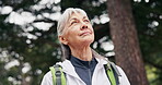Senior, happy woman and thinking in forest for hiking adventure, scenic break and explore nature. Fresh air, pensioner or trekking in woods with reflection, sightseeing or healthy aging with backpack