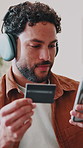 Phone, credit card or man in home with music membership, payment or premium streaming service. Money transfer, internet banking or happy person with tech, subscription sign up or headphone audio