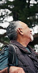 Senior, happy man and thinking in woods for hiking adventure, scenic break and nature appreciation. Fresh air, pensioner or trekking pause in forest with calm reflection, sightseeing and explore view