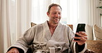 Spa, phone and mature man happy for hospitality rating, social media and check in at lodge. Person, technology and laugh in reception area with mobile app, luxury accommodation and bathrobe to relax