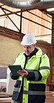 Carpenter, man and inspection in warehouse with tablet, review manufacturing and quality assurance. Mature person, walk and reading in factory with tech, woodwork operations or supervisor with report