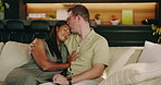 Love, couple and cuddle on sofa with kiss, healthy marriage and bonding together on weekend. Romance, happy people and embrace in home with unwind, laughing or affection in interracial relationship