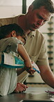 Dad, child and cleaning home, spray and wipe table for learning hygiene for help with flare. Kitchen chores, boy and father teaching housework, funny or talking for bacteria safety with happy family