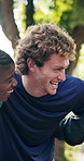 Happy, fitness and huddle with people in nature for outdoor workout mission or social gathering. Active, group or friends with hug or smile for exercise, health or wellness together in park or forest