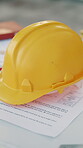 Architecture, blueprint and hardhat at worksite for planning, renovation and remodeling project. Floorplan, paper and helmet with draft for property development, safety and engineering compliance