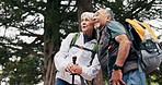 Hiking, point and old couple in nature with discussion, smile and adventure together for retirement. Happy, senior people and talk outdoor in woods with trekking, wellness or interracial relationship