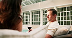 Couple, relax and wine at resort with holiday, conversation and bonding together on anniversary trip. Happy, mature people and talk in luxury hotel with alcohol drink, vacation or marriage commitment